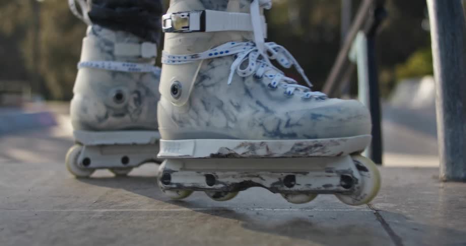 Rollerblades pause at the top of outdoor steps then roll away