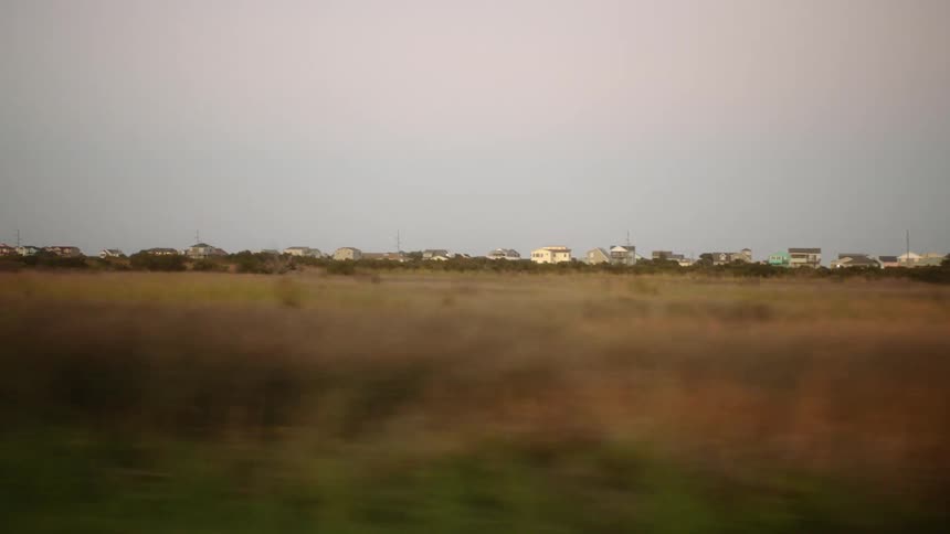 Dry grass field near a small town in the countryside