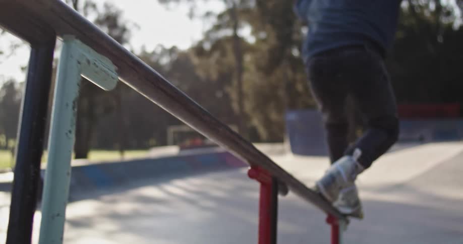 A man is roller blading off a railing during the day