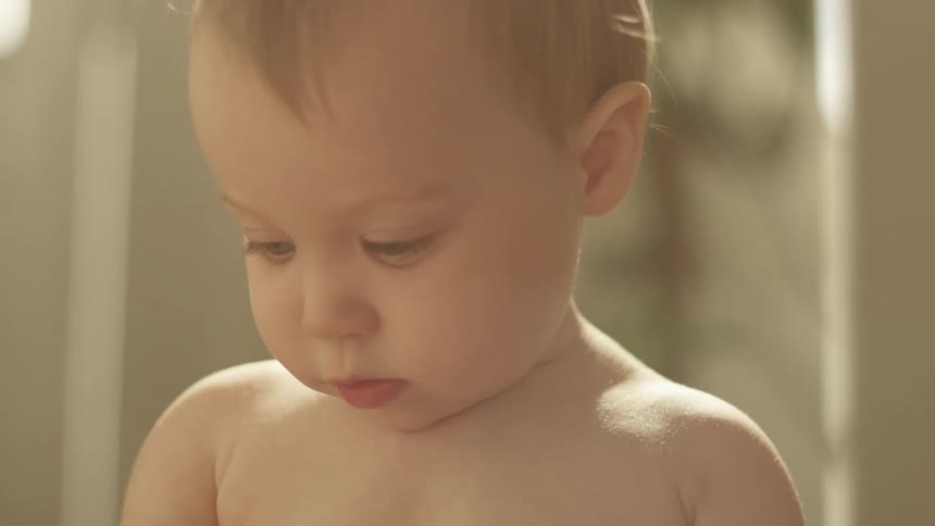 A baby in a room with a wall in the background