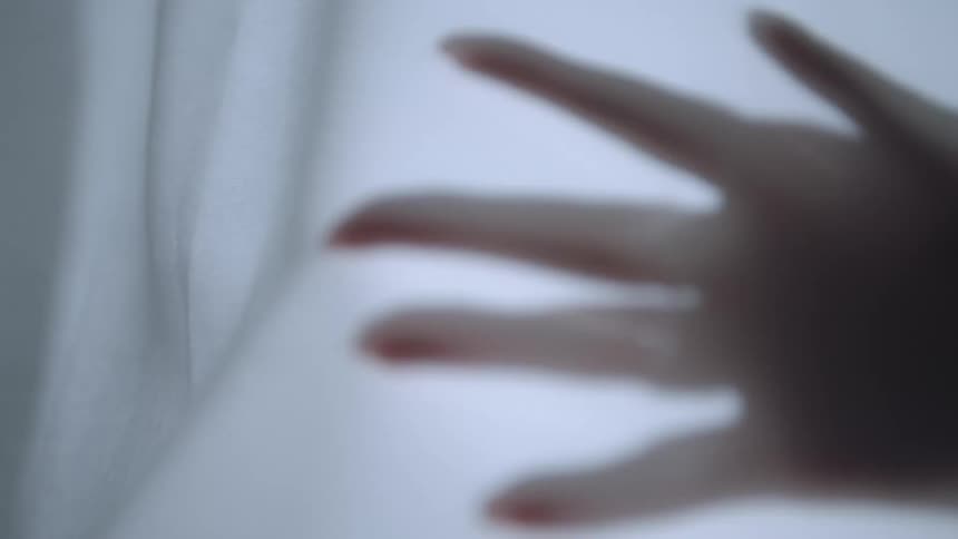 A person is touching a curtain with their hand