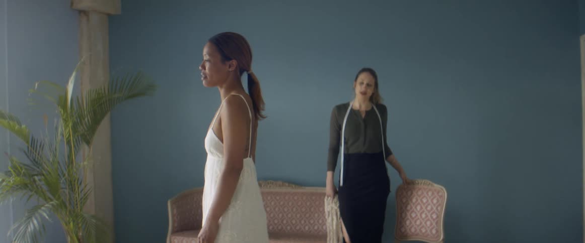 Tailor looking at a client wearing a white dress