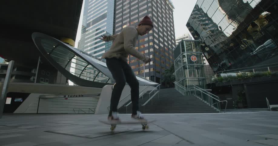 A man riding a skateboard with buildings an overpass the sky and clouds in the background