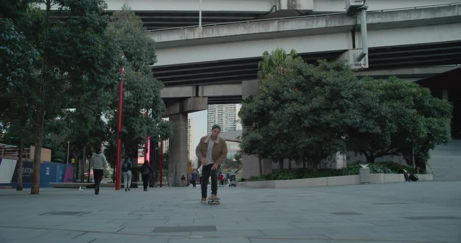 A skateboarder riding by pedestrians downtown in a large city
