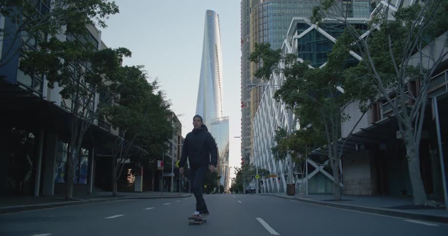 A person is skateboarding in a downtown city
