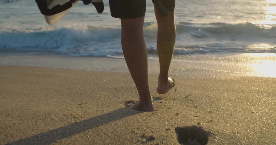 Barefoot person is walking in the sand on a beach