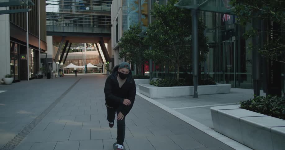 A teenage boy skateboards in a downtown area