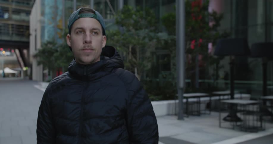A man is skateboarding through a downtown city