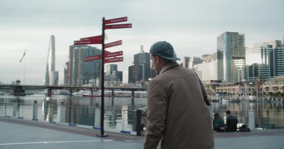 A man is skateboarding in a downtown city