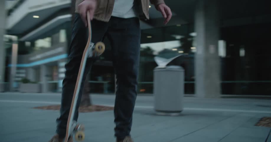 A man is skateboarding through a downtown city