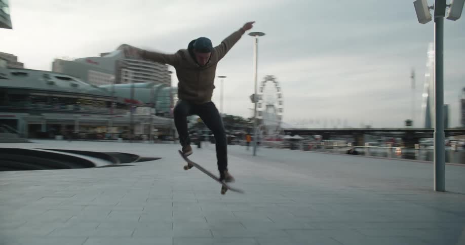 A man is skateboarding through a downtown city