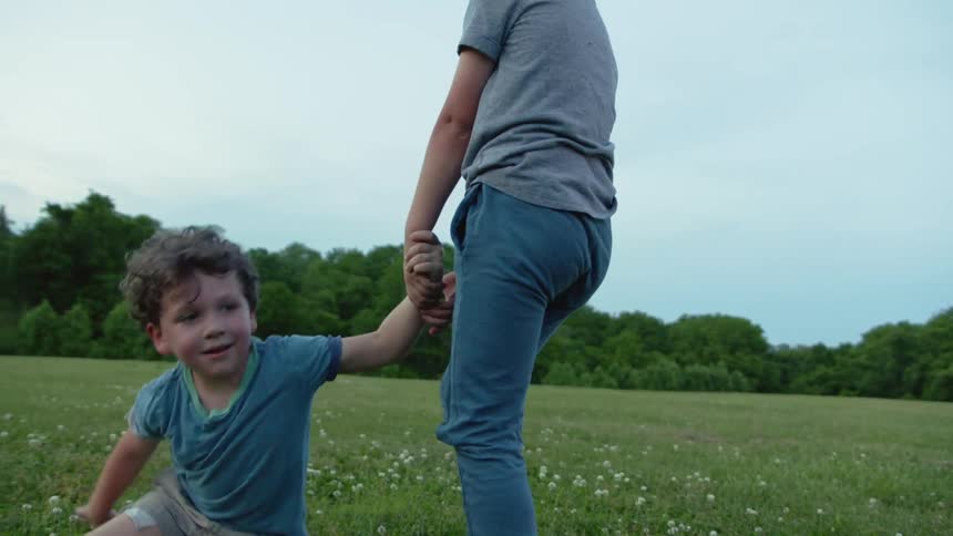 Two boys enjoy themselves in the grassy field