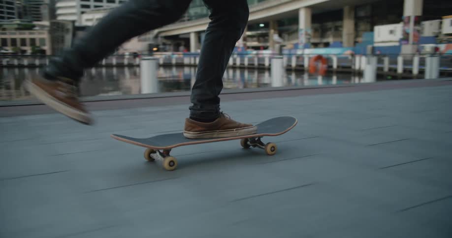 A person riding a skateboard near the harbour on the city at morning
