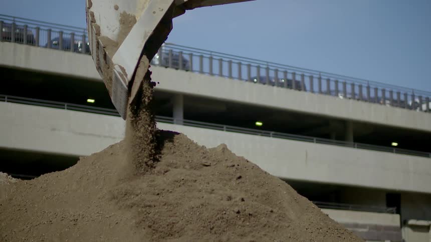 An excavation machine drops dirt into a pile