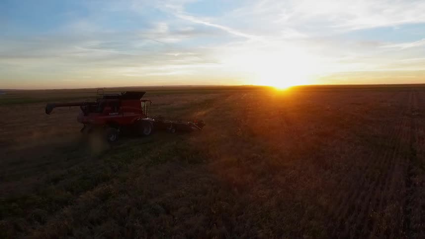 The sun is setting in the distance of this farm