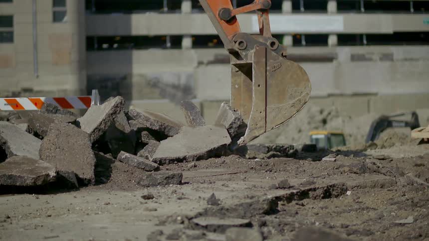 A bucket crane picks up debris