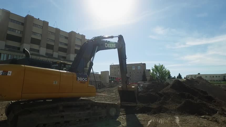 Backhoe digging in an urban lot
