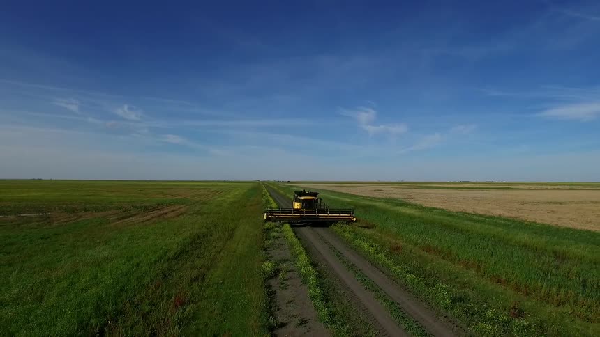 A tractor works a large farm field