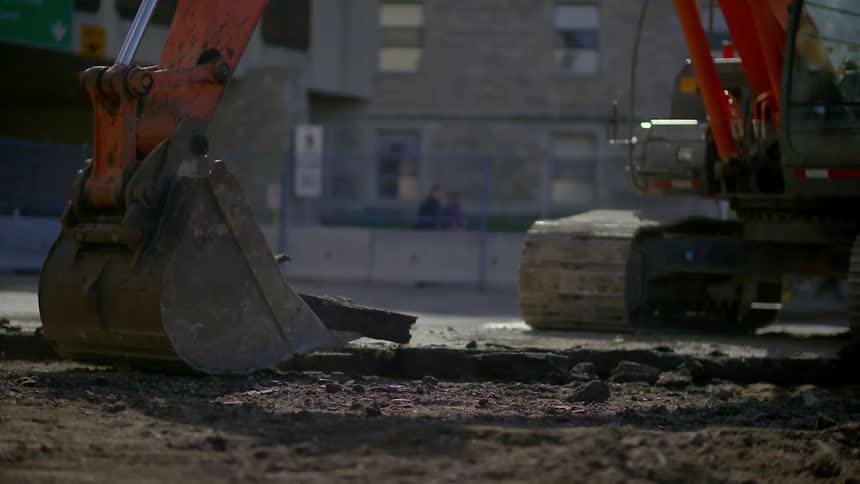 Heavy equipment bucket picking up broken concrete