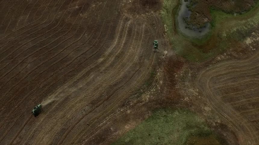 Aerial view of vehicles working fields below