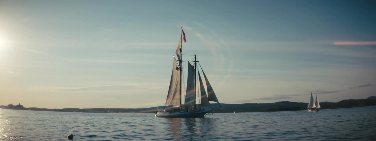 Sail boats on calm water with a gentle breeze and glowing sun