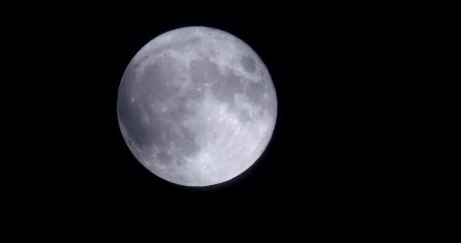 Various shades of white showing terrain of moon contrast with blackness of night sky
