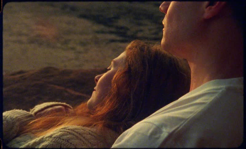 Young couple sitting outdoors looking at the sunset