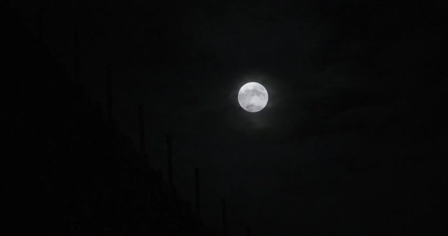 A fence with the sky and the moon in the background