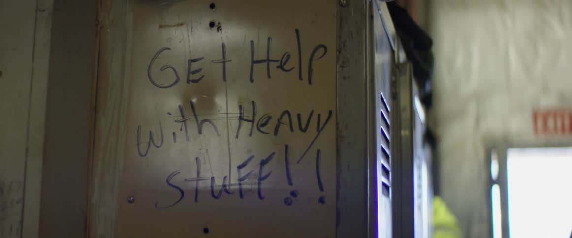 A message to get help with heavy stuff is written on an employee locker