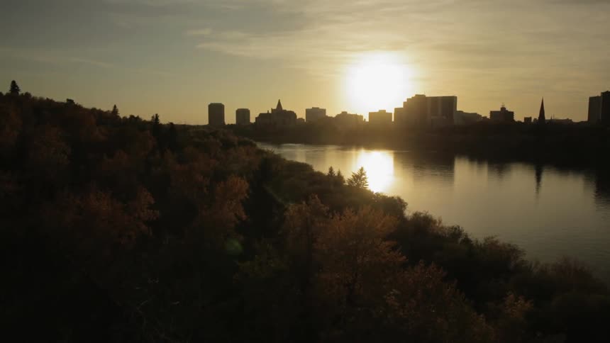 A body of water sits before a city at sunset