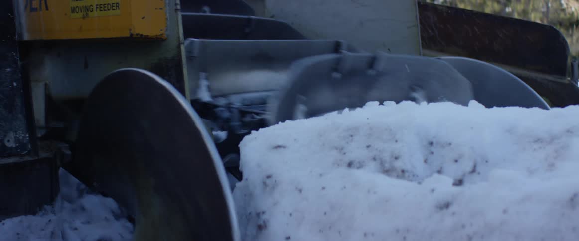 A snow clearing machine clearing snow during the day