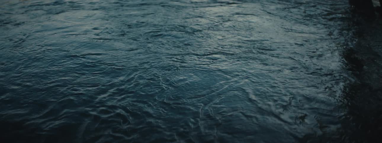 A view of water bubbling in the ocean near a pier