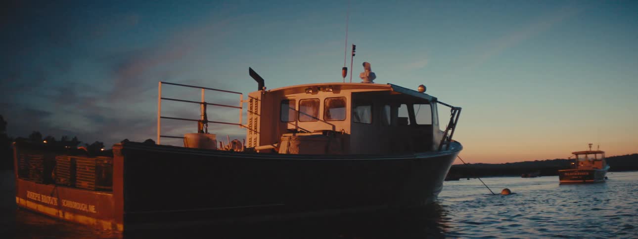 A ship is moving on the ocean water at dusk