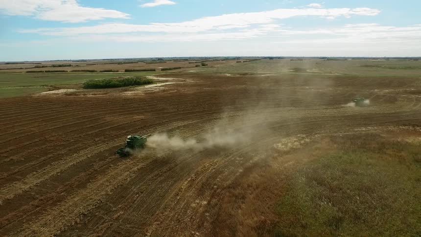 Aerial view of vehicles working a large farm field