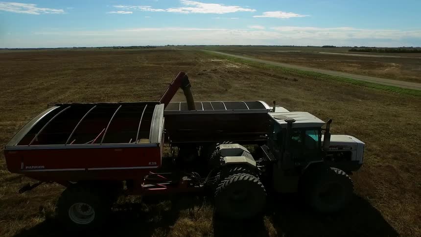Large farm machines are parked on a field