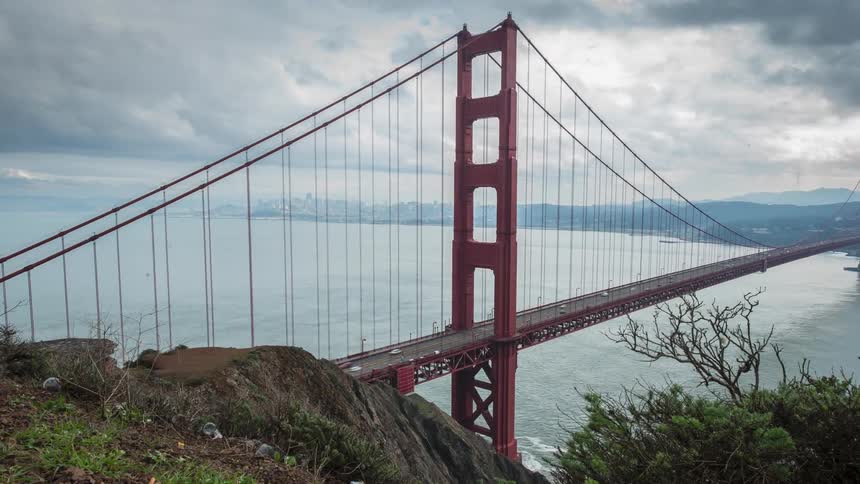 Time lapse of traffic crossing a large bridge on a very cloudy day