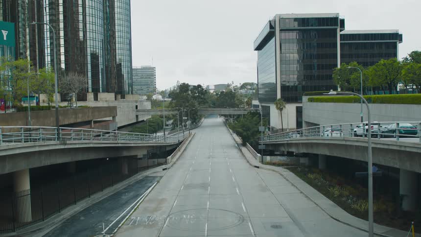 A wide city street that looks to be empty with tall buildings visible at a distance