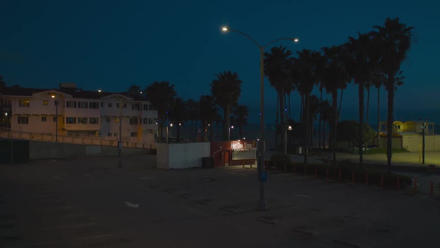 An empty parking lot in a city is displayed at night