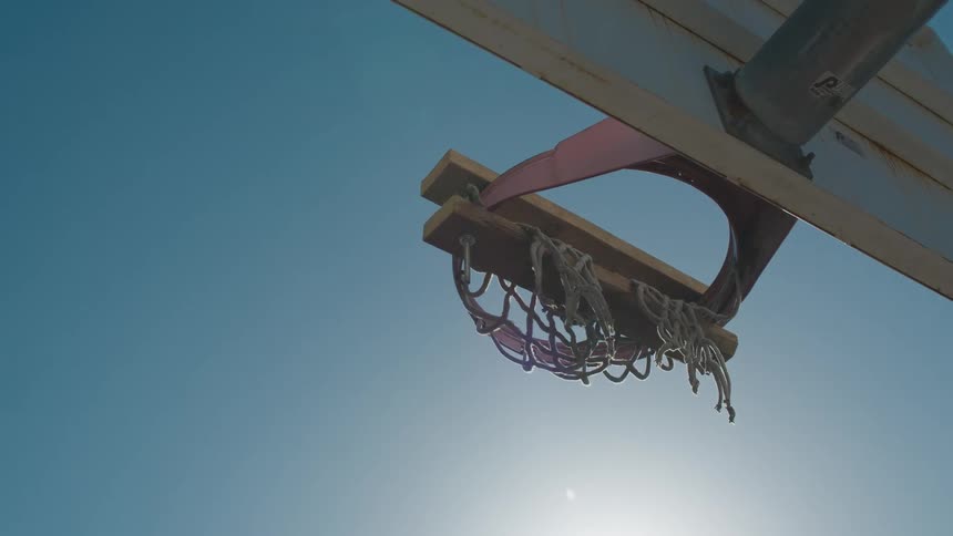 Sunlight shining down on a basketball hoop outdoors