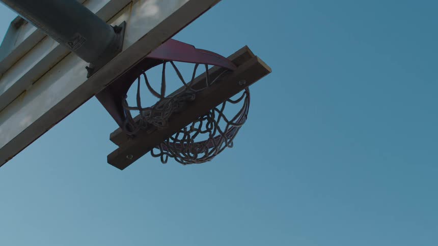 An outdoor basketball hoop has a clamp on it to keep it from being used