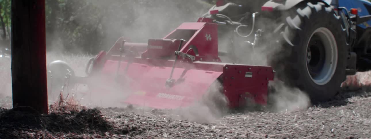 A person drives a tractor in a field