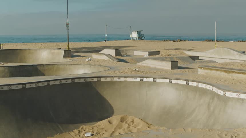 A skate park with the beach the ocean the sky and clouds in the background
