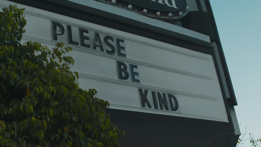 A look at a street sign saying please be kind