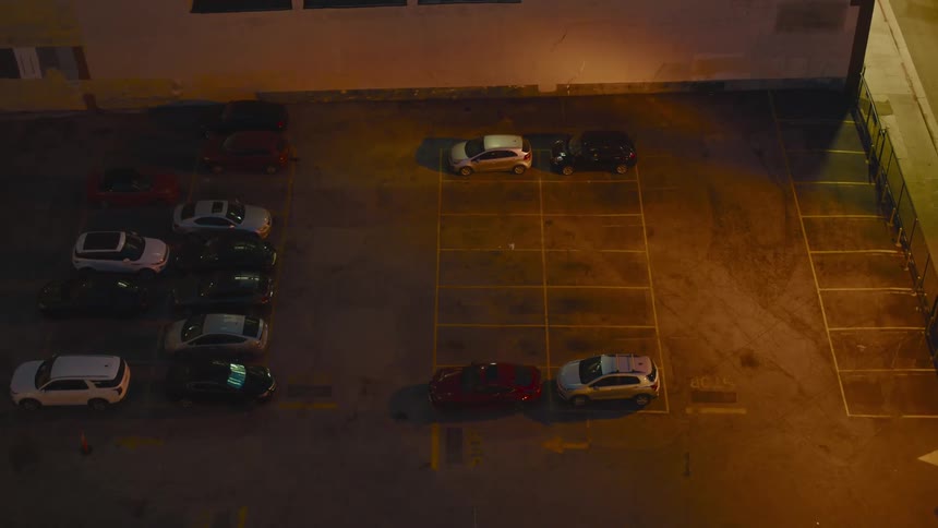 Cars in a paved parking lot at night