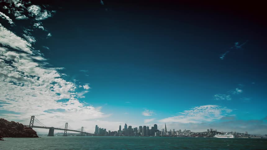Time-lapse of some river traffic with a large city in the distance