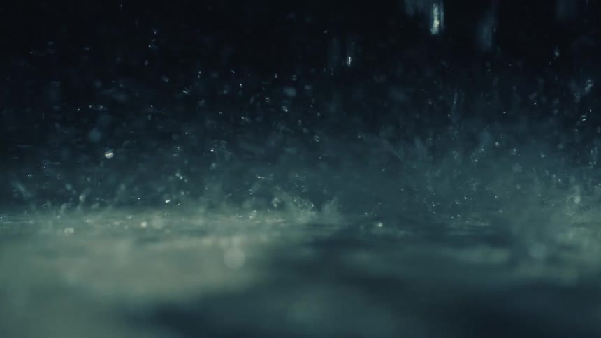 Rain falling and splashing on a body of water