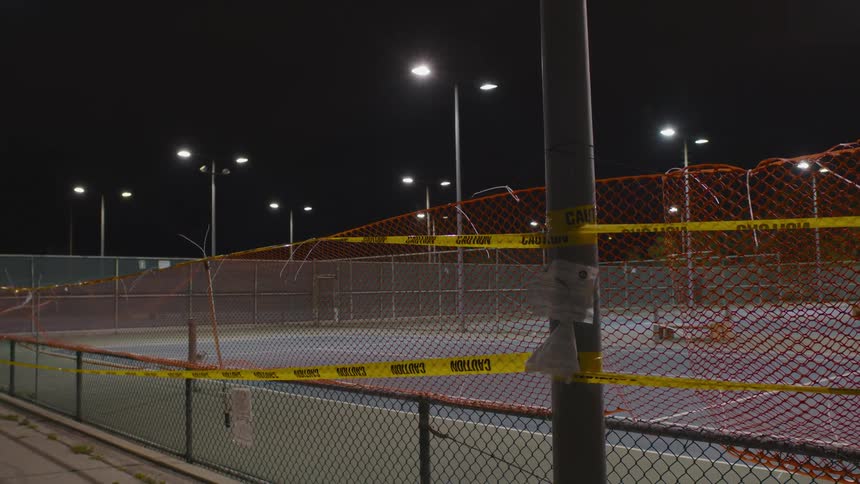 Caution tape is covering a court in a park