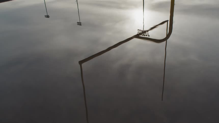 A puddle with a reflection of a football goal the sky and clouds