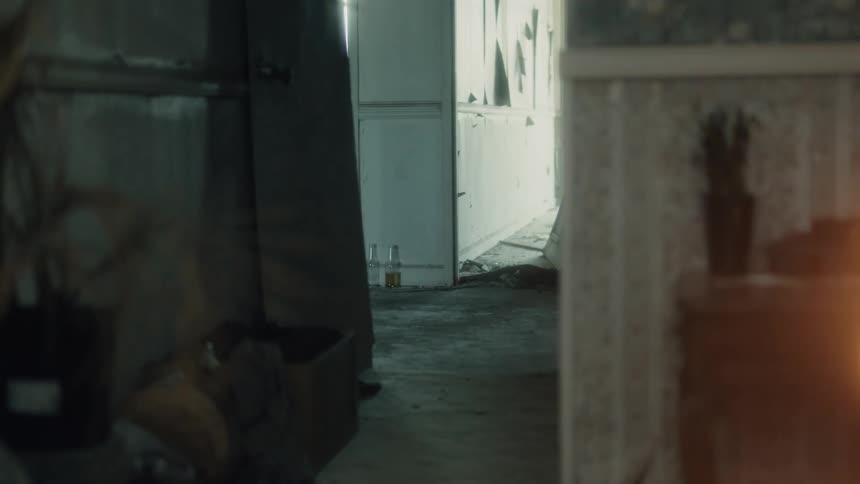 A room with fire burning with a wall and doorway in the background