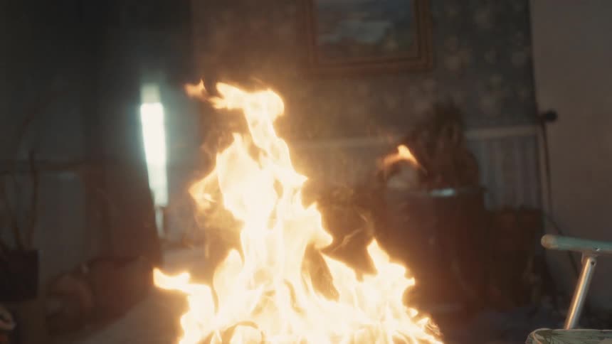 A table in a home burns as it is engulfed in flames
